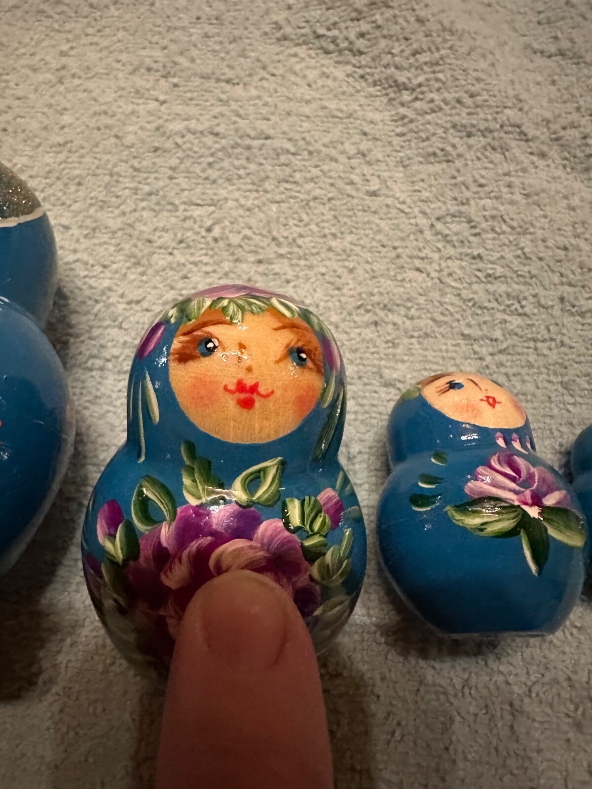 blue nesting doll with green and gold sparkle accents with purple flowers