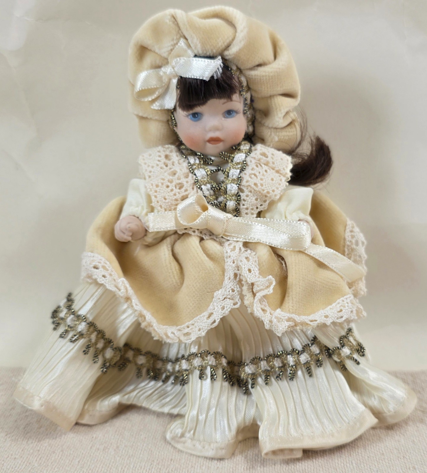 Vintage 7″ Porcelain Girl Doll Beige Outfit Bonnet Dress Black Hair Blue Eyes