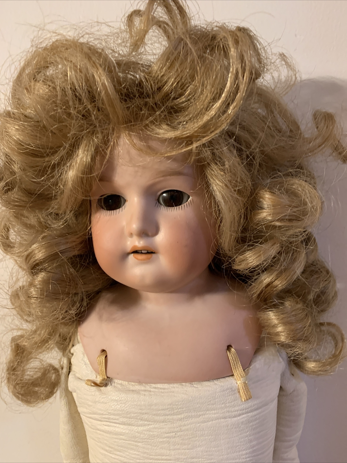 22 1/2” Armand Marseilles antique doll. Stationary eyes. Curly synthetic wig.