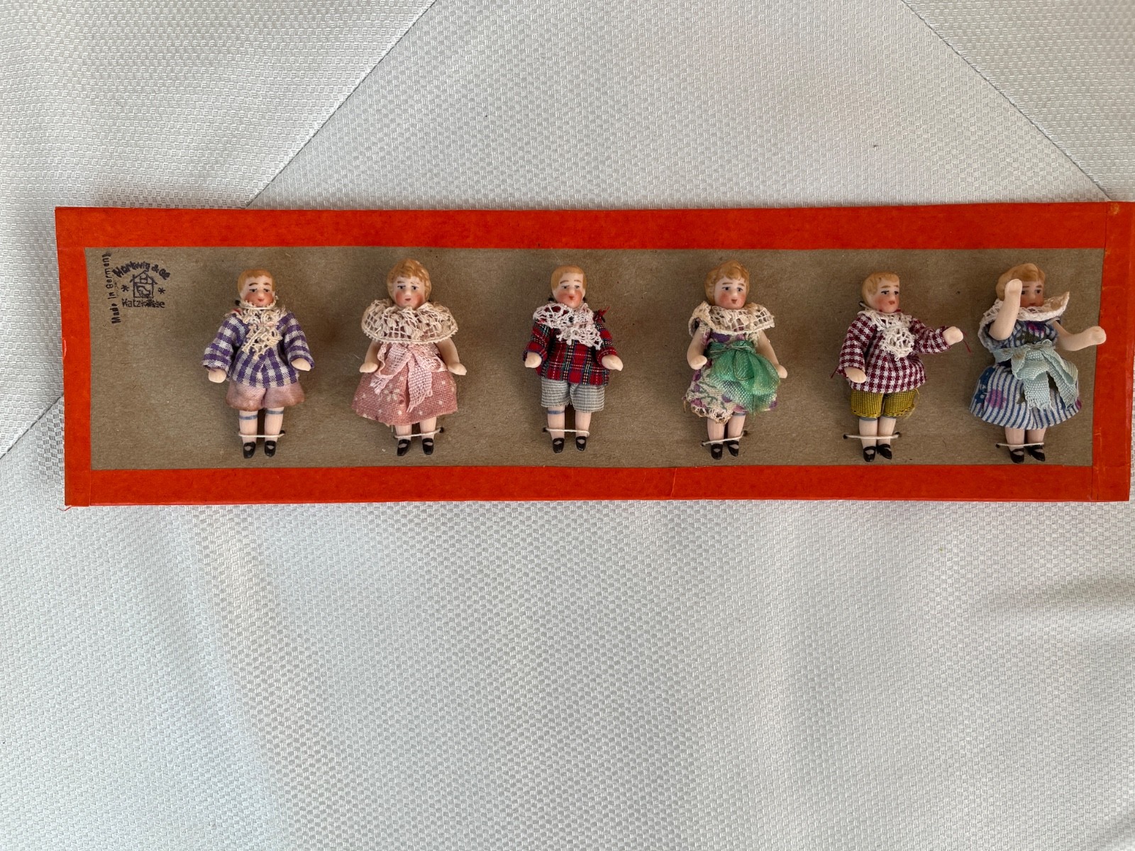 6 clothed antique porcelain dolls on sample card – Hertwig & Co.