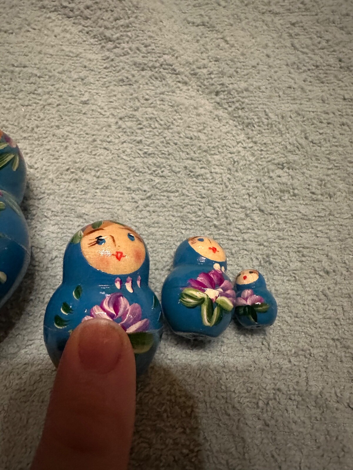 blue nesting doll with green and gold sparkle accents with purple flowers