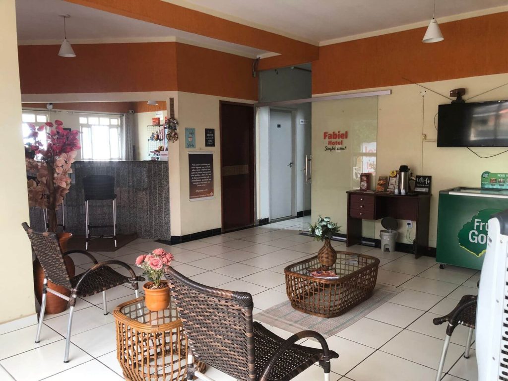 Recepção do Hotel Fabiel em Cuiabá, MT, com balcão de atendimento, poltronas e área de espera para hóspedes.
